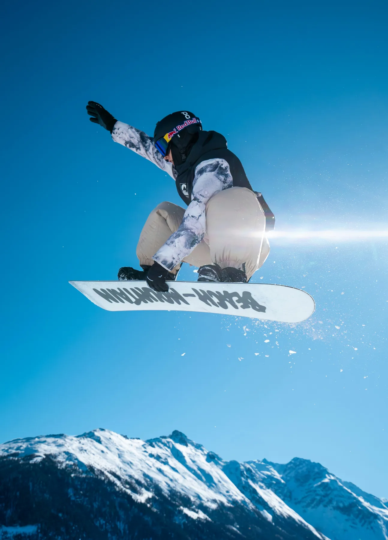 Snowboarder high above a snowy alpine landscape